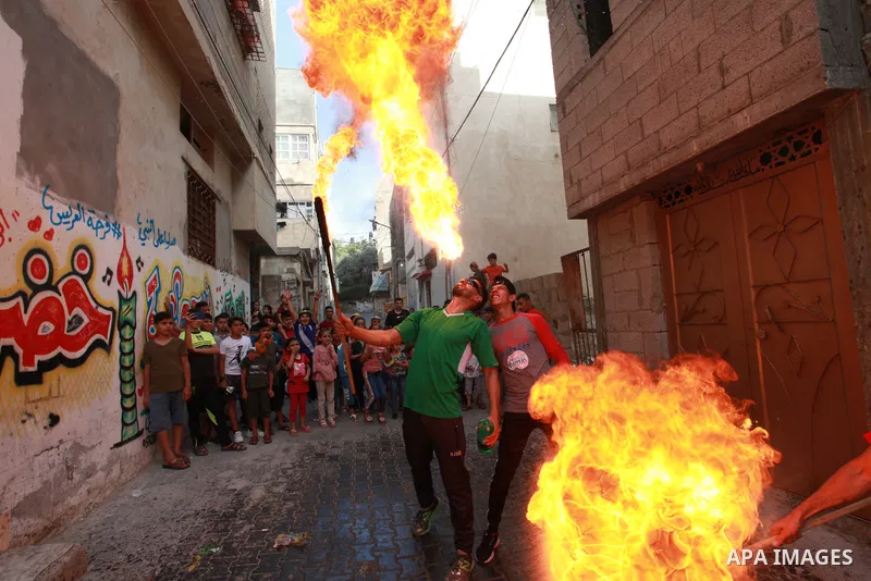 Palestinian volunteers perform acrobatic show in front of children during a mental health support session in Gaza city on June 9, 2021. As Gaza tries to recover from the deadly 11-day Israeli attack, mothers and mental h...