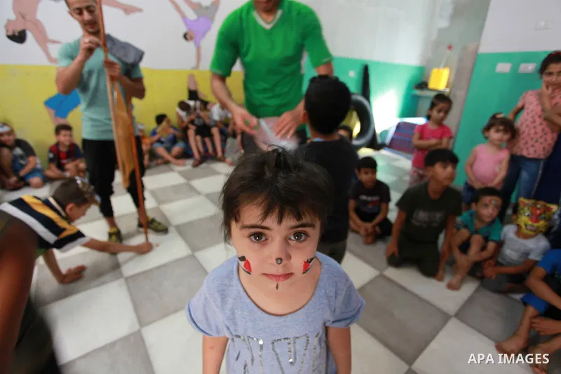 Palestinian children cheer during a mental health support session by Palestinian volunteers through acrobatic performances in Gaza city on June 9, 2021. As Gaza tries to recover from the deadly 11-day Israeli attack, mot...
