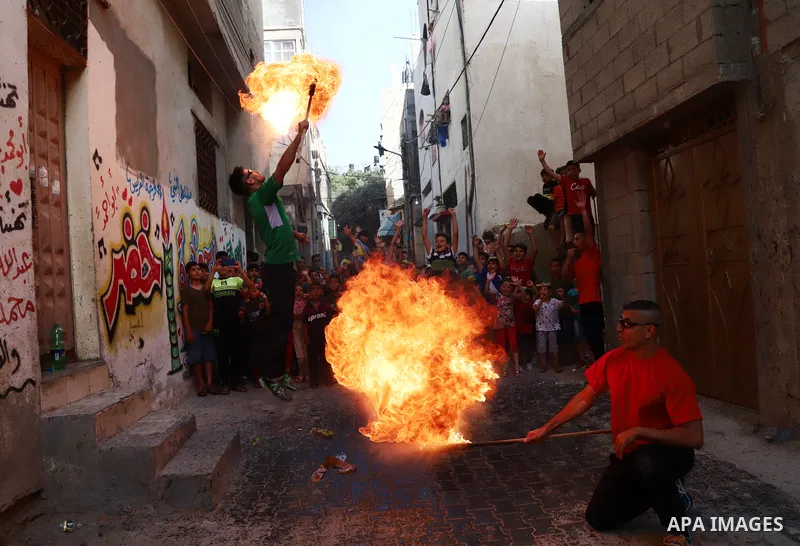 Palestinian volunteers perform acrobatic show in front of children during a mental health support session in Gaza city on June 9, 2021. As Gaza tries to recover from the deadly 11-day Israeli attack, mothers and mental h...