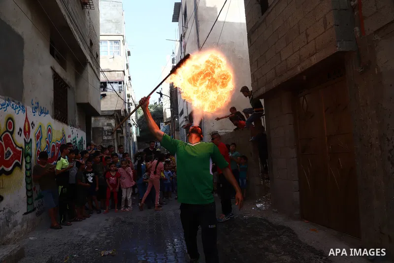 Palestinian volunteers perform acrobatic show in front of children during a mental health support session in Gaza city on June 9, 2021. As Gaza tries to recover from the deadly 11-day Israeli attack, mothers and mental h...
