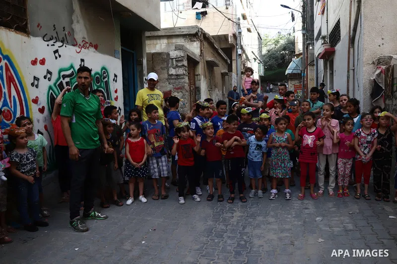Palestinian children cheer during a mental health support session by Palestinian volunteers through acrobatic performances in Gaza city on June 9, 2021. As Gaza tries to recover from the deadly 11-day Israeli attack, mot...