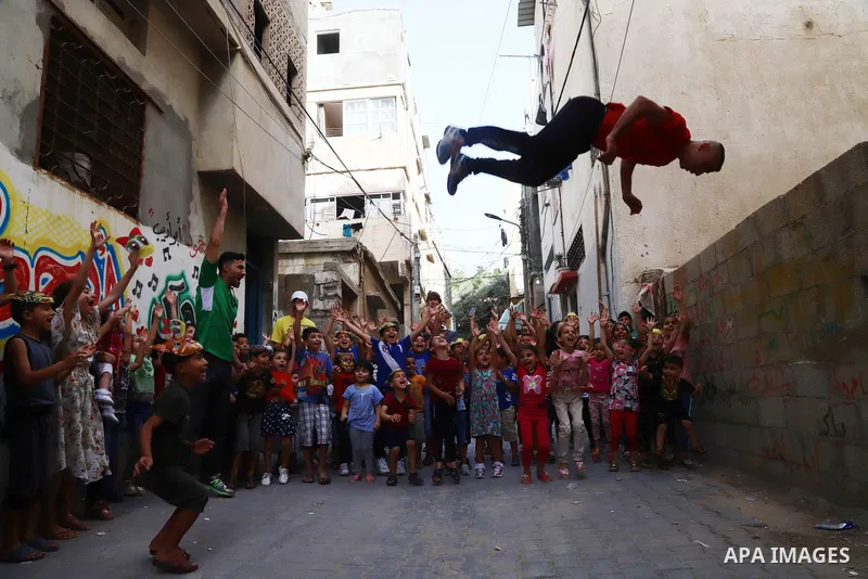 Palestinian volunteers perform acrobatic show in front of children during a mental health support session in Gaza city on June 9, 2021. As Gaza tries to recover from the deadly 11-day Israeli attack, mothers and mental h...