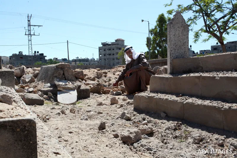 An elderly Palestinian man, 74, Mohammed Abu Al-Kas inspects graves of his relatives in a cemetery in the Shejaiya neighborhood, east of Gaza City, after dozens of graves were destroyed during the latest Israeli military...