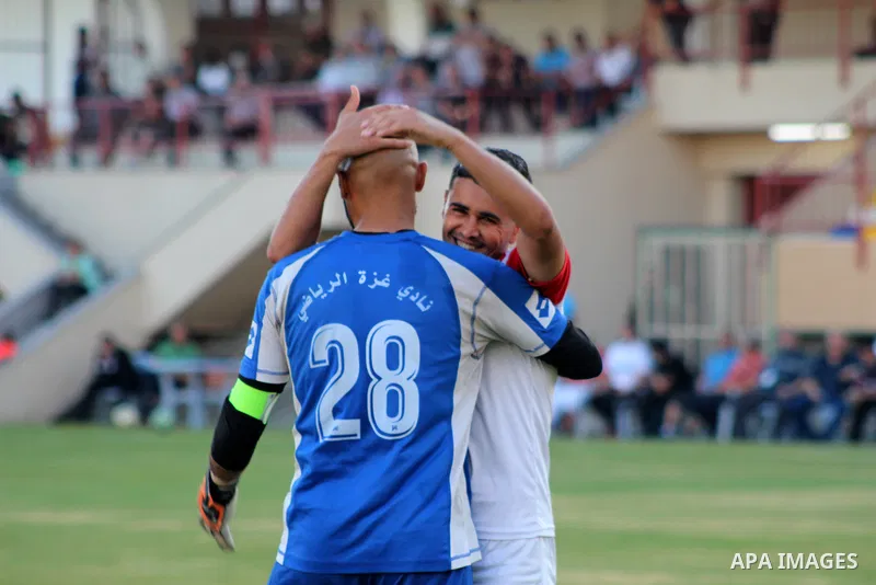 Palestinian football players of Al-Jala' Sports (Orange) and Gaza Sports (white) compete during match of the Al-Quds Ramadan Championship, at Palestine Stadium in Gaza City, on June 6, 2021. Photo by Marihan Al-Khalidi
