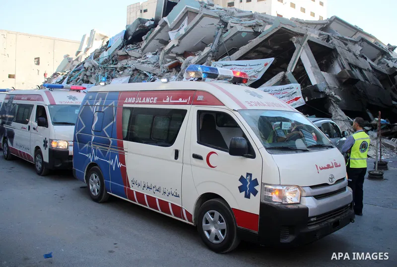 Palestinians gather around Ambulances donated by the Democratic Reform movement, near the rubbles of Jala' Tower which destroyed on May 15 during Israeli air-strike, in Gaza city on June 6, 2021. Photo by Marihan Al-Khal...