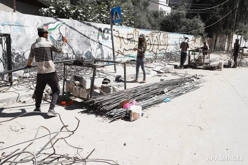 Palestinian workers straighten steel rod as part of the recycling of salvaged construction materials from buildings destroyed during the May 2021 conflict between Hamas and Israel, in Gaza City on June 5, 2021. Gaza’s ho...