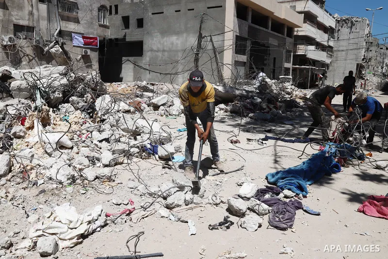 Palestinian workers straighten steel rod as part of the recycling of salvaged construction materials from buildings destroyed during the May 2021 conflict between Hamas and Israel, in Gaza City on June 5, 2021. Gaza’s ho...