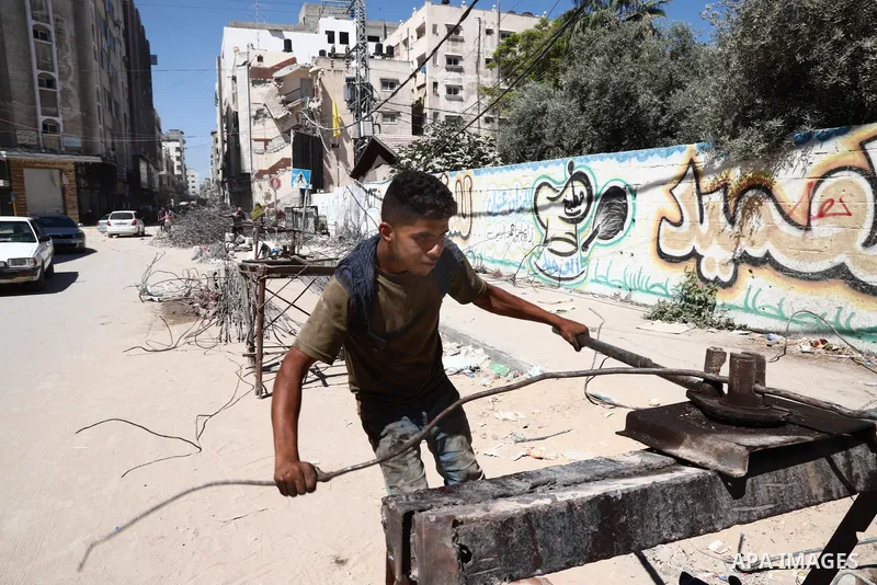 Palestinian workers straighten steel rod as part of the recycling of salvaged construction materials from buildings destroyed during the May 2021 conflict between Hamas and Israel, in Gaza City on June 5, 2021. Gaza’s ho...