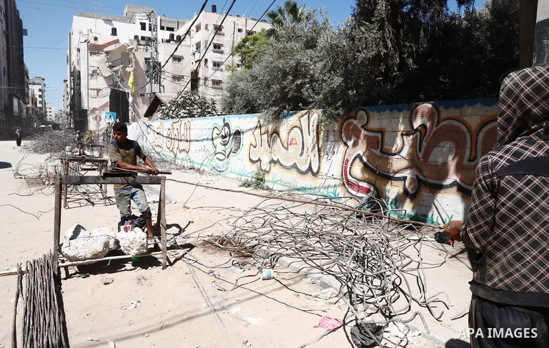 Palestinian workers straighten steel rod as part of the recycling of salvaged construction materials from buildings destroyed during the May 2021 conflict between Hamas and Israel, in Gaza City on June 5, 2021. Gaza’s ho...