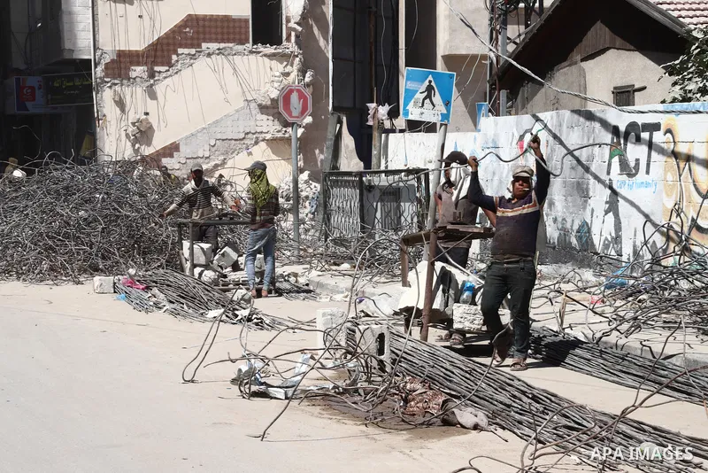 Palestinian workers straighten steel rod as part of the recycling of salvaged construction materials from buildings destroyed during the May 2021 conflict between Hamas and Israel, in Gaza City on June 5, 2021. Gaza’s ho...