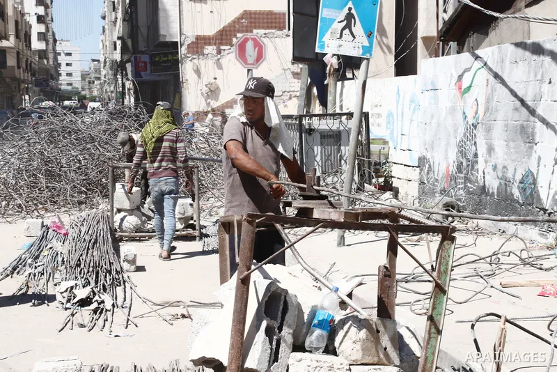 Palestinian workers straighten steel rod as part of the recycling of salvaged construction materials from buildings destroyed during the May 2021 conflict between Hamas and Israel, in Gaza City on June 5, 2021. Gaza’s ho...
