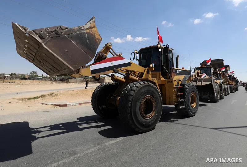 A convoy of bulldozers, excavators and trucks loaded with construction equipment provided by Egypt arrives at the Palestinian side of the Rafah border crossing between Egypt and the Palestinian Gaza Strip enclave on June...