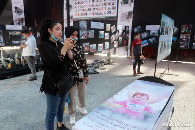 A Palestinian vlogger Bessan Awda, visits an exhibition "Witness to the crime" in Gaza city on June 3, 2021. The Egyptian-brokered truce ended 11 days of heavy Israeli bombing of Gaza and rocket fire from the impoverishe...