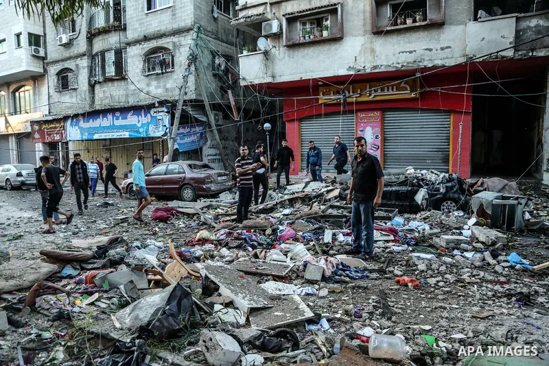 Palestinian families are pictured in a street after evacuating their homes in Gaza city on May 19, 2021, due to heavy shelling by the Israeli military. Photo by Bashar Taleb