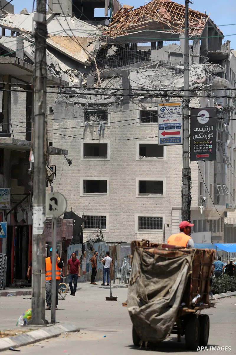 Palestinians walk past a building destroyed by Israeli missile strikes in Gaza City on May 22, 2021, following a ceasefire between Israel and Hamas movment. UNICEF delivered today lifesaving critical humanitarian supplie...