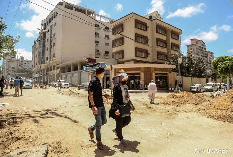 Palestinians walk past a building destroyed by Israeli missile strikes in Gaza City on May 22, 2021, following a ceasefire between Israel and Hamas movment. UNICEF delivered today lifesaving critical humanitarian supplie...