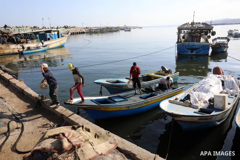 Palestinian fishermen work at Gaza City's main port, on May 25, 2021, after Israeli security forces allowed a limited number of Palestinian fishing boats to return to sea following a ceasefire in the recent conflict. Pho...