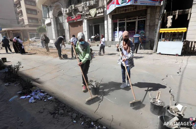 Palestinian volunteers and municipal workers clear the rubble of the buildings, recently destroyed by Israeli strikes, in Gaza City on May 25, 2021 after a cease-fire ending 11 days of deadly violence between Israel and...