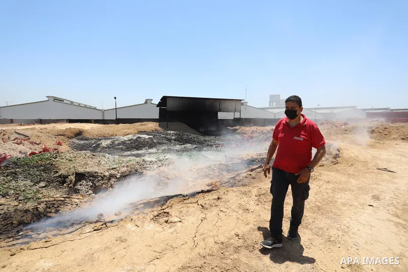 A Palestinian worker salvages items from the damaged Coca Cola factory in Gaza's industrial area, on May 25, 2021, which was hit by Israeli strikes prior to a cease-fire ending 11 days of deadly violence between Israel a...