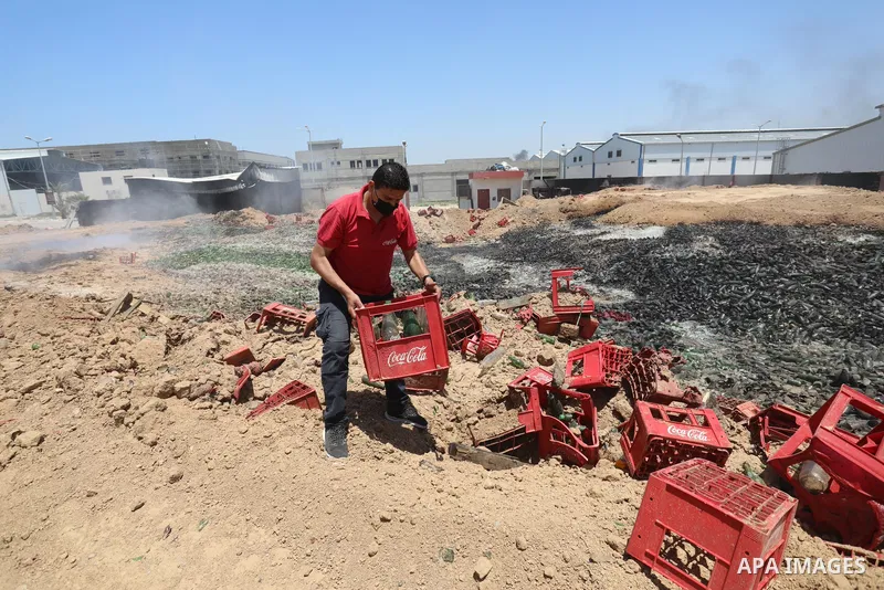 A Palestinian worker salvages items from the damaged Coca Cola factory in Gaza's industrial area, on May 25, 2021, which was hit by Israeli strikes prior to a cease-fire ending 11 days of deadly violence between Israel a...