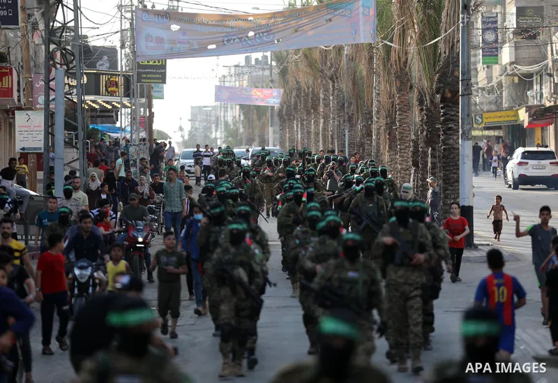 Members of Ezz-Al Din Al-Qassam Brigades, the armed wing of the Palestinian Hamas movement parade in an anti-Israel rally Al-Bureij refugee camp in the central Gaza Strip on May 28, 2021. - The Egyptian-brokered truce en...