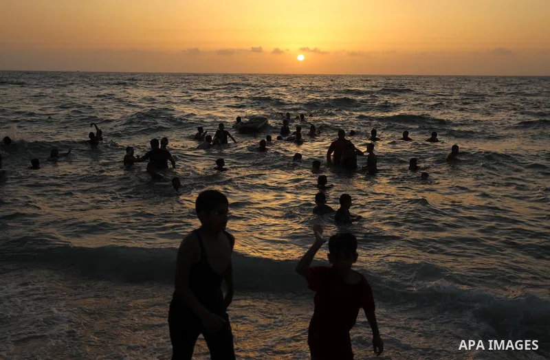 Palestinians spend time at the beach to escape the hot weather and the ongoing power cuts, in Deir al-Balah in the center of Gaza Strip on May 28, 2021. Photo by Ashraf Amra