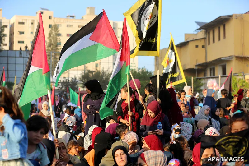 Supporters of al-Quds Brigades, the armed wing of the Palestinian Islamic Jihad movement, gather to watch them parade in the streets of Gaza City on May 29, 2021, more than a week after a ceasefire brought an end to 11 d...