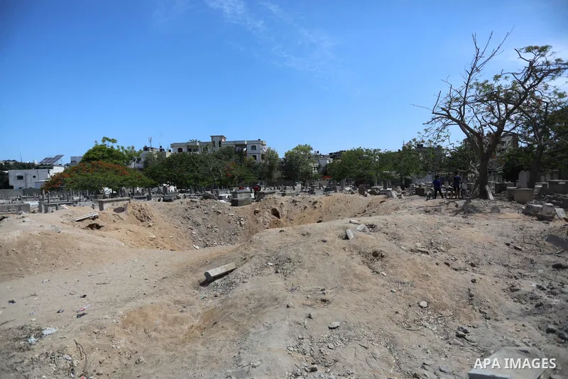 Palestinians inspect the damage around tombs in the old Shujaiya cemetery in Gaza City on May 30, 2021, after recent Israeli bombings. A ceasefire was reached late last week after 11 days of deadly violence between Israe...