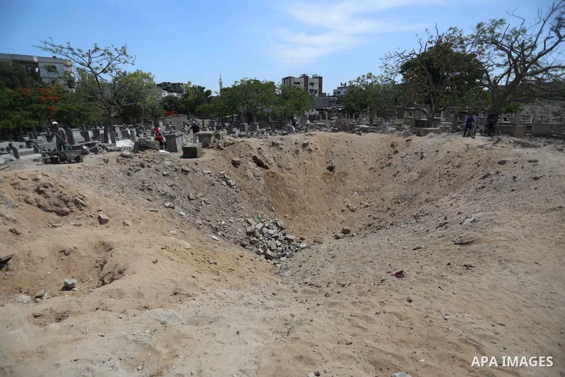 Palestinians inspect the damage around tombs in the old Shujaiya cemetery in Gaza City on May 30, 2021, after recent Israeli bombings. A ceasefire was reached late last week after 11 days of deadly violence between Israe...