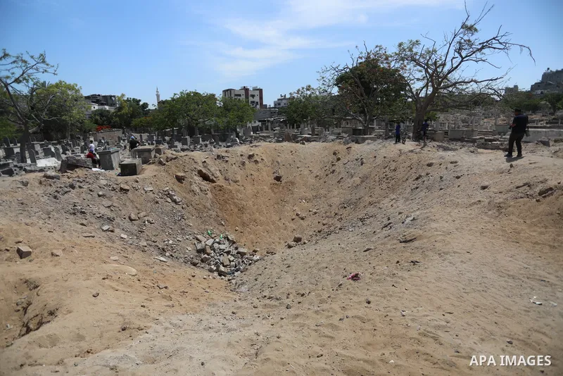 Palestinians inspect the damage around tombs in the old Shujaiya cemetery in Gaza City on May 30, 2021, after recent Israeli bombings. A ceasefire was reached late last week after 11 days of deadly violence between Israe...