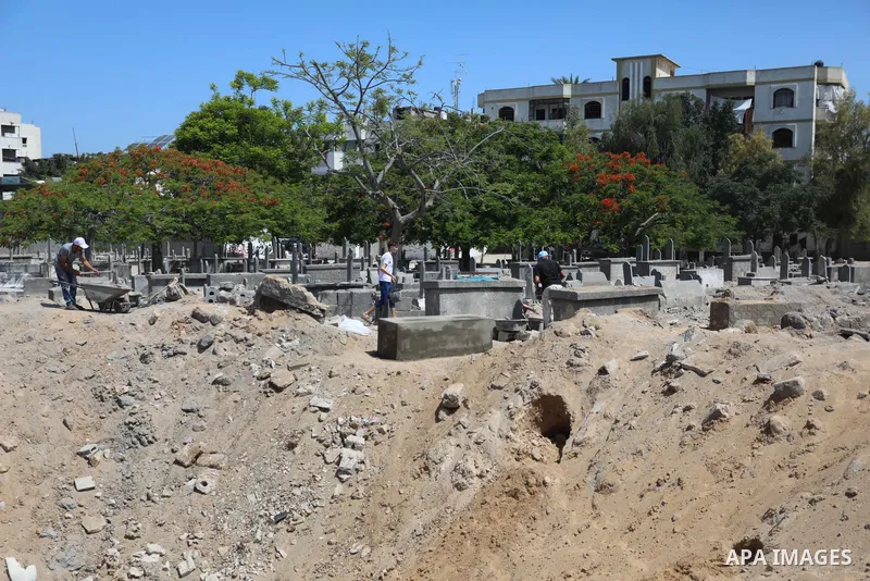 Palestinians inspect the damage around tombs in the old Shujaiya cemetery in Gaza City on May 30, 2021, after recent Israeli bombings. A ceasefire was reached late last week after 11 days of deadly violence between Israe...