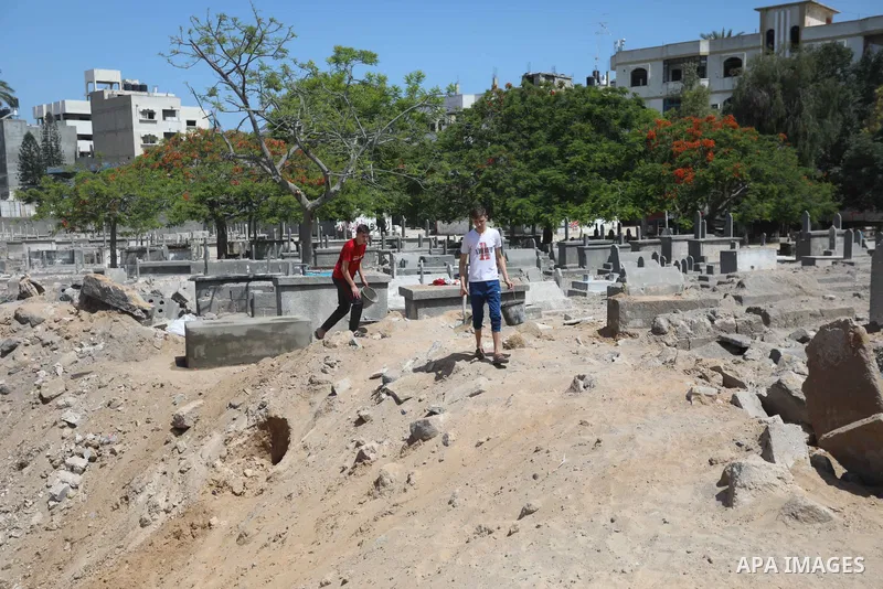 Palestinians inspect the damage around tombs in the old Shujaiya cemetery in Gaza City on May 30, 2021, after recent Israeli bombings. A ceasefire was reached late last week after 11 days of deadly violence between Israe...