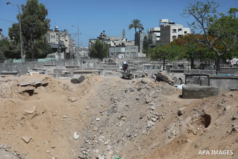 Palestinians inspect the damage around tombs in the old Shujaiya cemetery in Gaza City on May 30, 2021, after recent Israeli bombings. A ceasefire was reached late last week after 11 days of deadly violence between Israe...