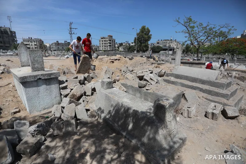 Palestinians inspect the damage around tombs in the old Shujaiya cemetery in Gaza City on May 30, 2021, after recent Israeli bombings. A ceasefire was reached late last week after 11 days of deadly violence between Israe...