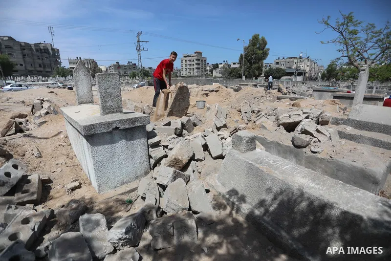 Palestinians inspect the damage around tombs in the old Shujaiya cemetery in Gaza City on May 30, 2021, after recent Israeli bombings. A ceasefire was reached late last week after 11 days of deadly violence between Israe...