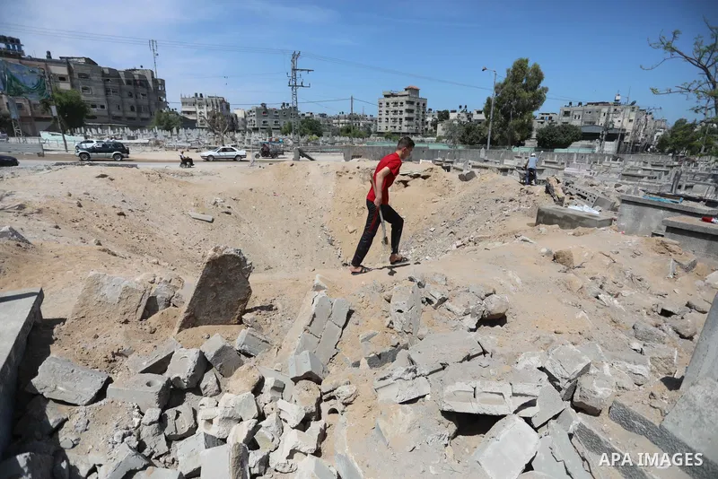 Palestinians inspect the damage around tombs in the old Shujaiya cemetery in Gaza City on May 30, 2021, after recent Israeli bombings. A ceasefire was reached late last week after 11 days of deadly violence between Israe...