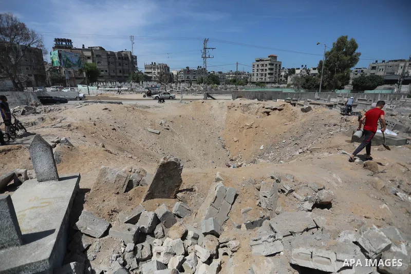 Palestinians inspect the damage around tombs in the old Shujaiya cemetery in Gaza City on May 30, 2021, after recent Israeli bombings. A ceasefire was reached late last week after 11 days of deadly violence between Israe...