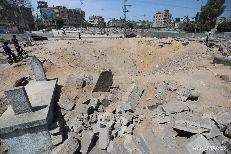 Palestinians inspect the damage around tombs in the old Shujaiya cemetery in Gaza City on May 30, 2021, after recent Israeli bombings. A ceasefire was reached late last week after 11 days of deadly violence between Israe...