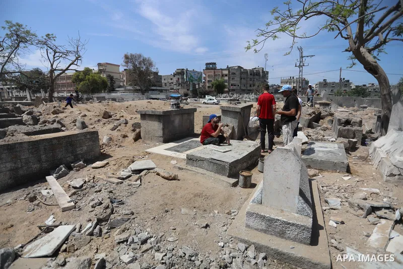 Palestinians inspect the damage around tombs in the old Shujaiya cemetery in Gaza City on May 30, 2021, after recent Israeli bombings. A ceasefire was reached late last week after 11 days of deadly violence between Israe...