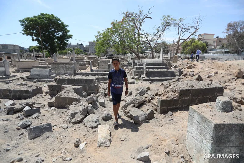 Palestinians inspect the damage around tombs in the old Shujaiya cemetery in Gaza City on May 30, 2021, after recent Israeli bombings. A ceasefire was reached late last week after 11 days of deadly violence between Israe...