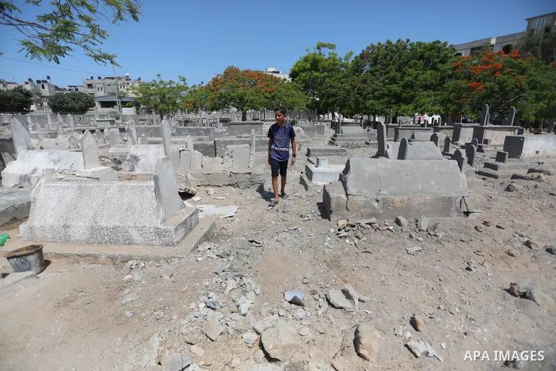 Palestinians inspect the damage around tombs in the old Shujaiya cemetery in Gaza City on May 30, 2021, after recent Israeli bombings. A ceasefire was reached late last week after 11 days of deadly violence between Israe...