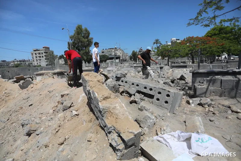 Palestinians inspect the damage around tombs in the old Shujaiya cemetery in Gaza City on May 30, 2021, after recent Israeli bombings. A ceasefire was reached late last week after 11 days of deadly violence between Israe...