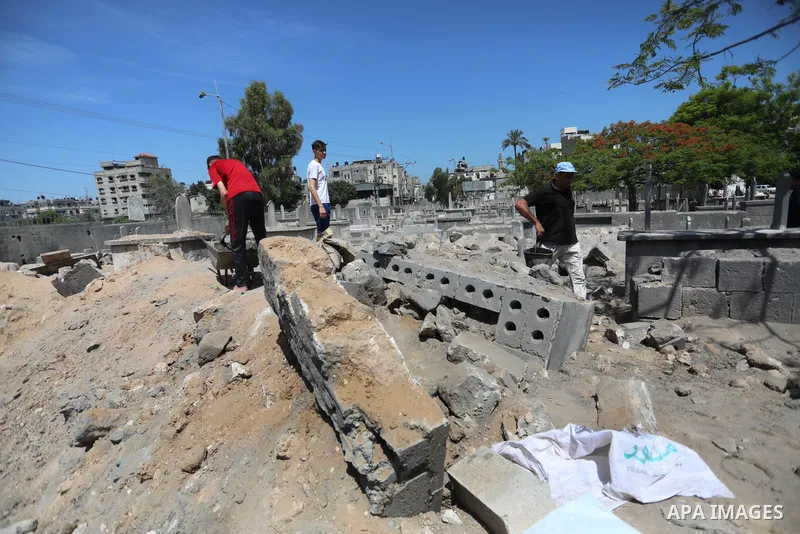 Palestinians inspect the damage around tombs in the old Shujaiya cemetery in Gaza City on May 30, 2021, after recent Israeli bombings. A ceasefire was reached late last week after 11 days of deadly violence between Israe...