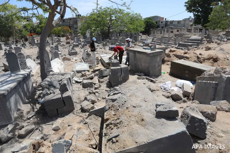 Palestinians inspect the damage around tombs in the old Shujaiya cemetery in Gaza City on May 30, 2021, after recent Israeli bombings. A ceasefire was reached late last week after 11 days of deadly violence between Israe...