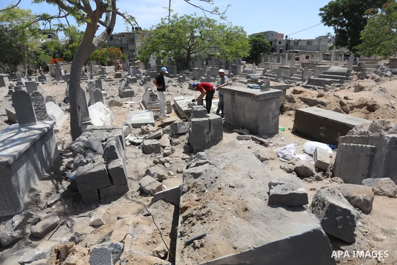 Palestinians inspect the damage around tombs in the old Shujaiya cemetery in Gaza City on May 30, 2021, after recent Israeli bombings. A ceasefire was reached late last week after 11 days of deadly violence between Israe...