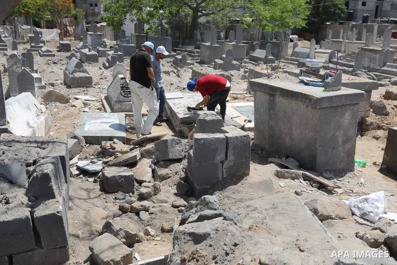 Palestinians inspect the damage around tombs in the old Shujaiya cemetery in Gaza City on May 30, 2021, after recent Israeli bombings. A ceasefire was reached late last week after 11 days of deadly violence between Israe...