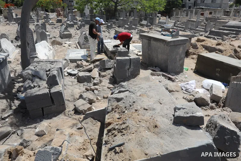 Palestinians inspect the damage around tombs in the old Shujaiya cemetery in Gaza City on May 30, 2021, after recent Israeli bombings. A ceasefire was reached late last week after 11 days of deadly violence between Israe...