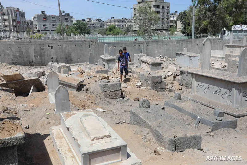 Palestinians inspect the damage around tombs in the old Shujaiya cemetery in Gaza City on May 30, 2021, after recent Israeli bombings. A ceasefire was reached late last week after 11 days of deadly violence between Israe...