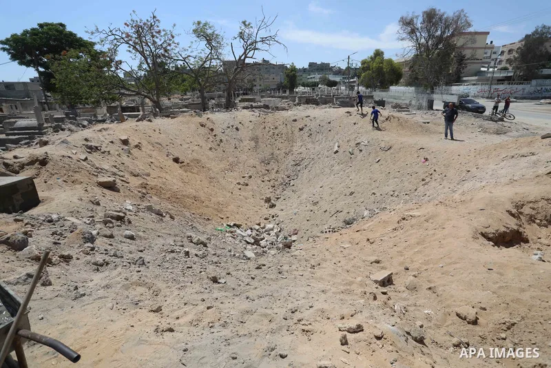Palestinians inspect the damage around tombs in the old Shujaiya cemetery in Gaza City on May 30, 2021, after recent Israeli bombings. A ceasefire was reached late last week after 11 days of deadly violence between Israe...