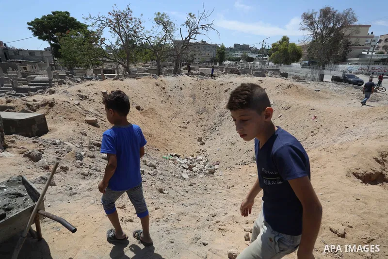 Palestinians inspect the damage around tombs in the old Shujaiya cemetery in Gaza City on May 30, 2021, after recent Israeli bombings. A ceasefire was reached late last week after 11 days of deadly violence between Israe...